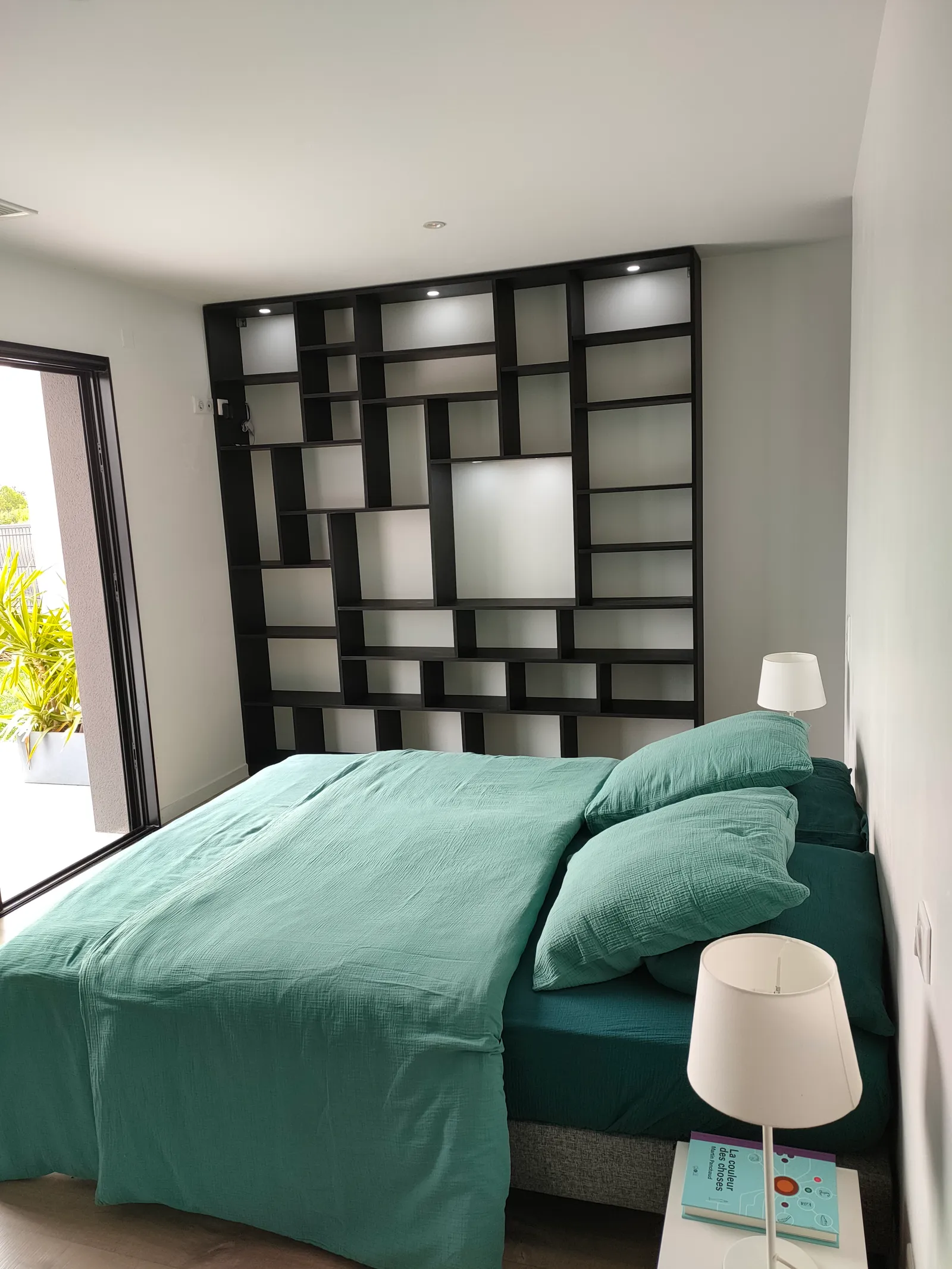 Chambre aménagée avec bibliothèque murale et éclairage intégré